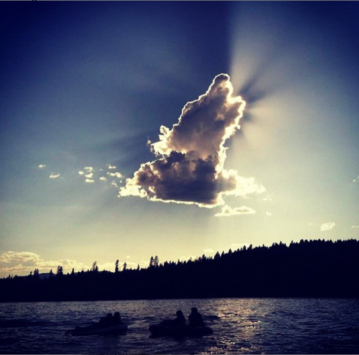 lac en bord de foret avec un nuage dans le ciel représentant un chien aboyant